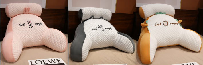 Three different colored car headrests with a small cartoon character on a brown surface.