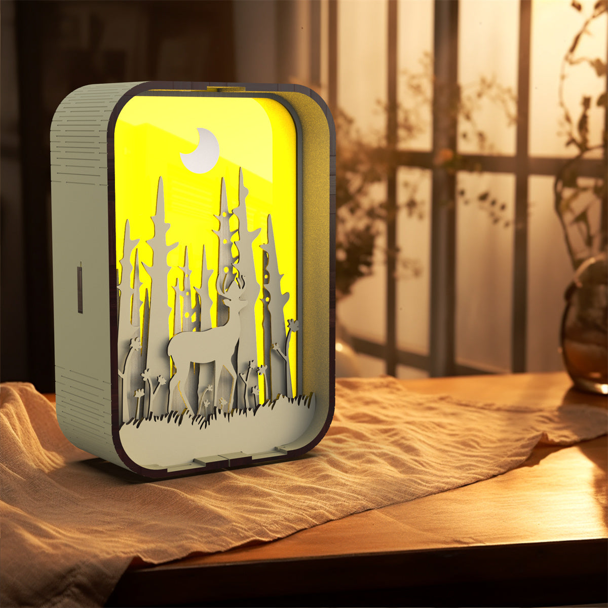 Decorative night light with deer design on a wooden surface