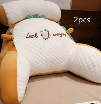 Two white pillows with cartoon face design and text on a brown surface.