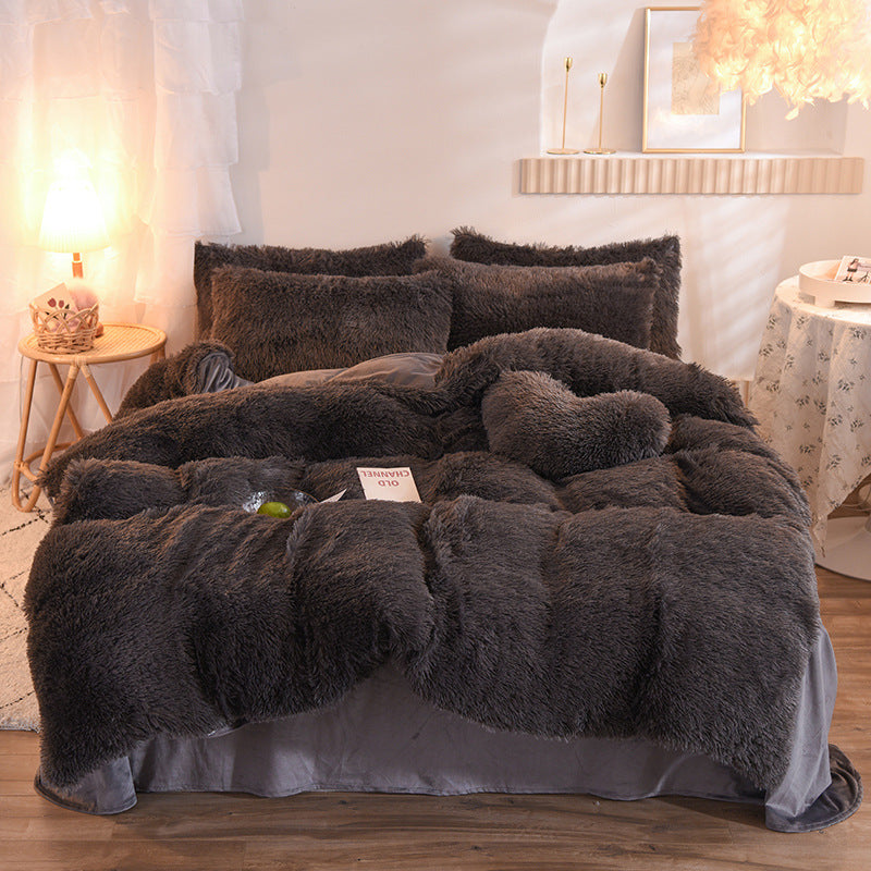 Fluffy dark gray comforter on a bed in a bedroom setting with soft lighting.