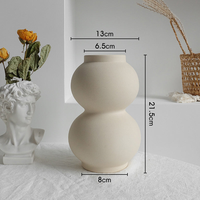 Beige ceramic vase with measurements on a white surface