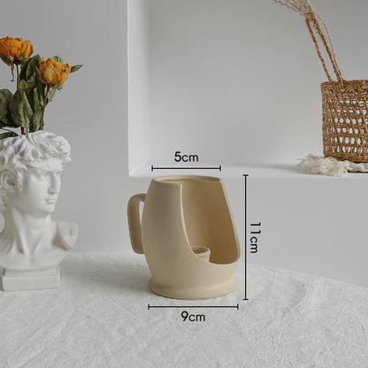 Beige ceramic mug with dimensions labeled on a white surface.