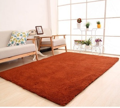 Living room with a red rug, sofa, and decorative items.