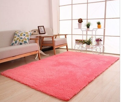 Living room with a pink rug, sofa, and decorative items.