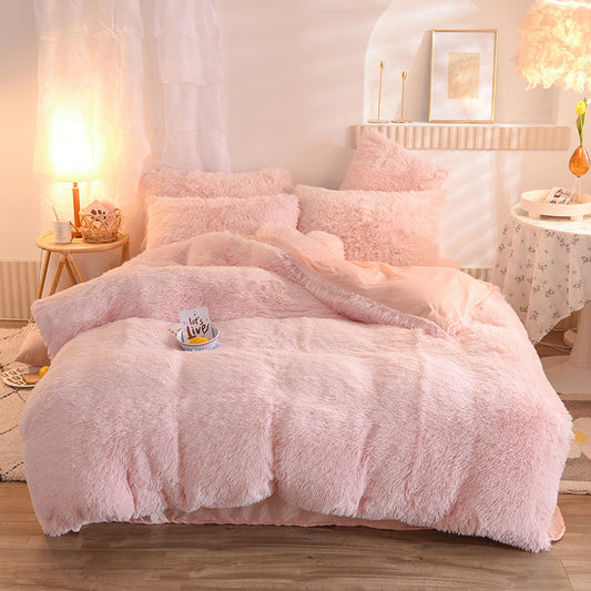 Pink fluffy comforter set on a bed in a cozy bedroom.