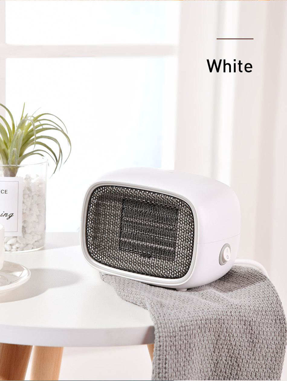 White space heater on a surface with a plant and decor in the background
