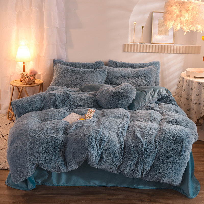 Blue fluffy comforter set on a bed in a bedroom with soft lighting.