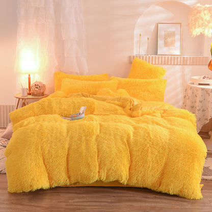 Yellow fluffy comforter set on a bed in a bedroom setting.
