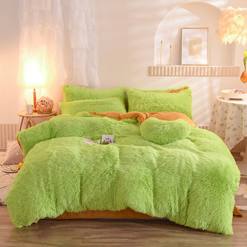 Green fluffy comforter set on a bed in a bedroom with soft lighting.
