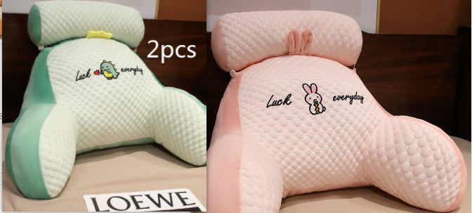Two plush pillows with cartoon designs on a surface, one green and one pink, with 'LOEWE' branding.