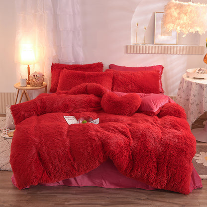 Red fluffy bedding set on a bed in a bedroom with soft lighting.