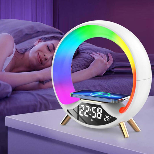 Multicolored night light with digital display and phone stand on a surface, with a person lying in bed in the background.