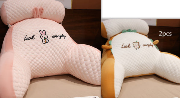 Two pink car headrests with cartoon designs and text on a wooden surface.