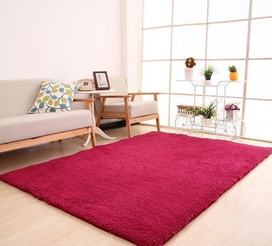 Living room with a red rug, beige sofa, and wooden coffee table.