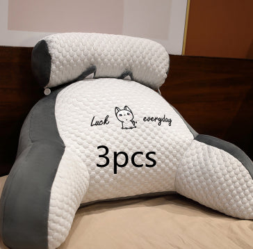 Three white and gray pillows with a brand logo on a wooden surface.