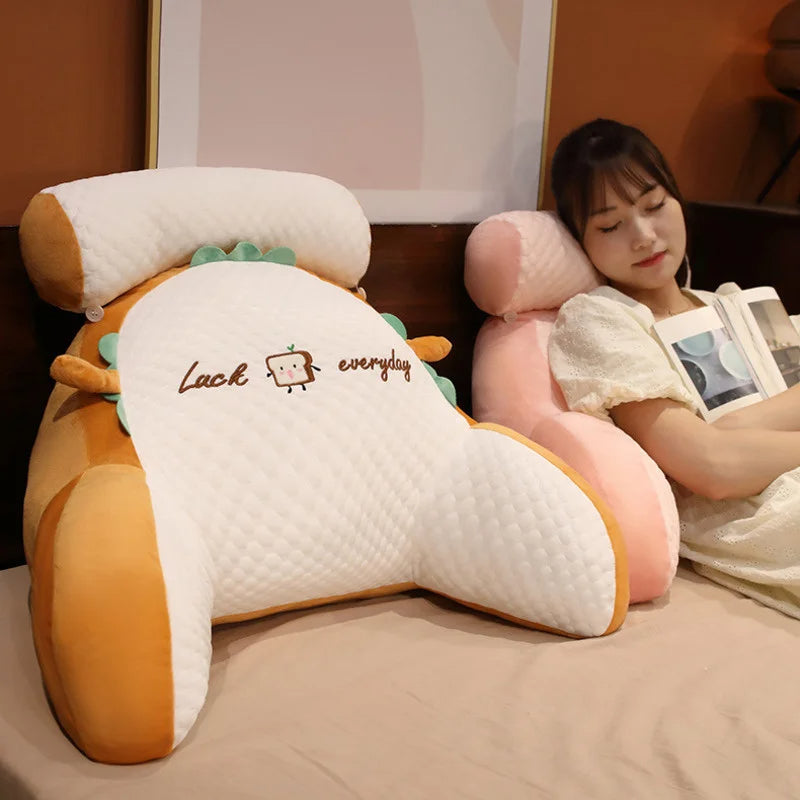 Woman lying on a dinosaur-shaped pillow with 'Luck everyday' text, surrounded by plush toys.