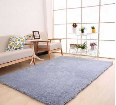 Blue rug in a living room with a couch, chair, and decorative items.