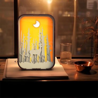 Decorative night light with deer design on a table.