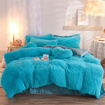 Turquoise fluffy comforter set on a bed in a bedroom setting.