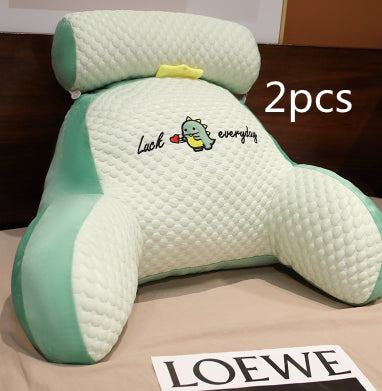 Two green and white pillows with a cartoon character on a brown surface, with 'LOEWE' branding visible.