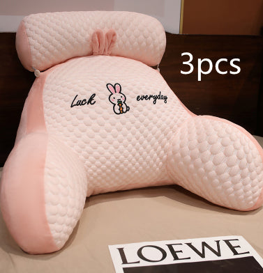 Three pink backrest pillows with a cartoon design and text on a brown surface, with 'LOEWE' branding visible.