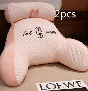 Two pink neck pillows with a brand label on a surface.