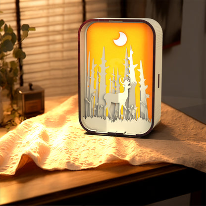 Decorative night light with animal silhouettes on a wooden surface