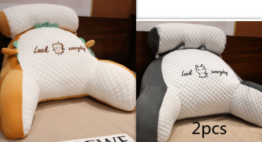 Two plush neck pillows with cartoon designs and text on a wooden surface.