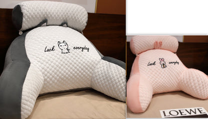 Two neck pillows, one gray and one pink, with text and branding on a wooden surface.