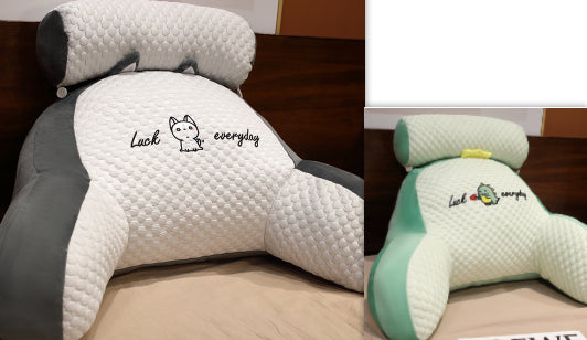 Two headrest covers with cartoon designs and text on a bed.