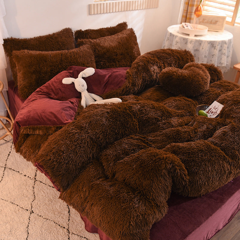 Brown fuzzy blanket draped over a bed with pillows and a stuffed animal in a bedroom setting.