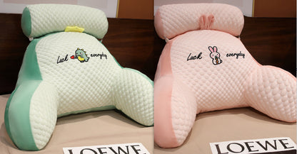 Two plush pillows with cartoon designs and 'LOEWE' branding on a wooden surface.